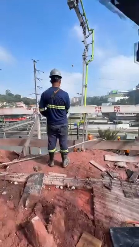 Operador da Bombax acompanhando o bombeamento com a lança ao fundo